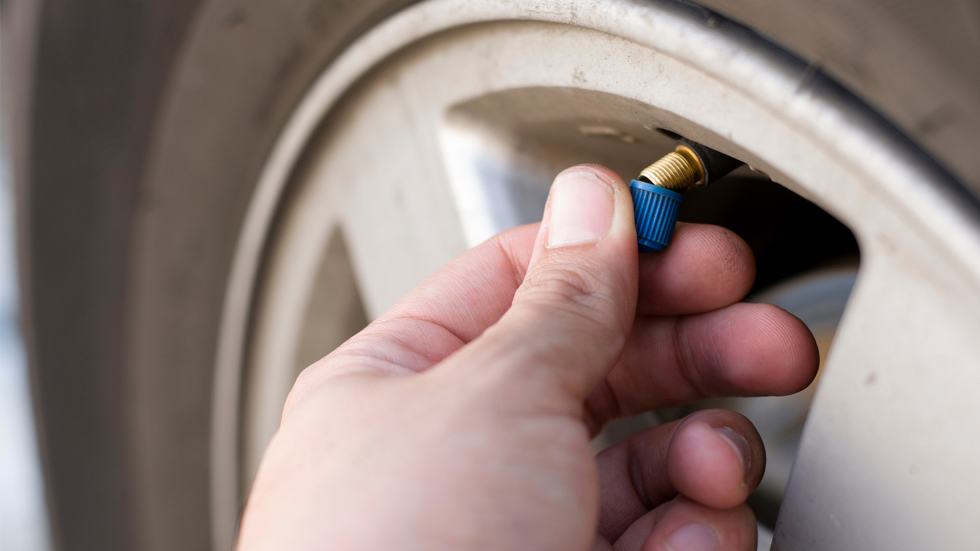 hand putting cap on a valve stem